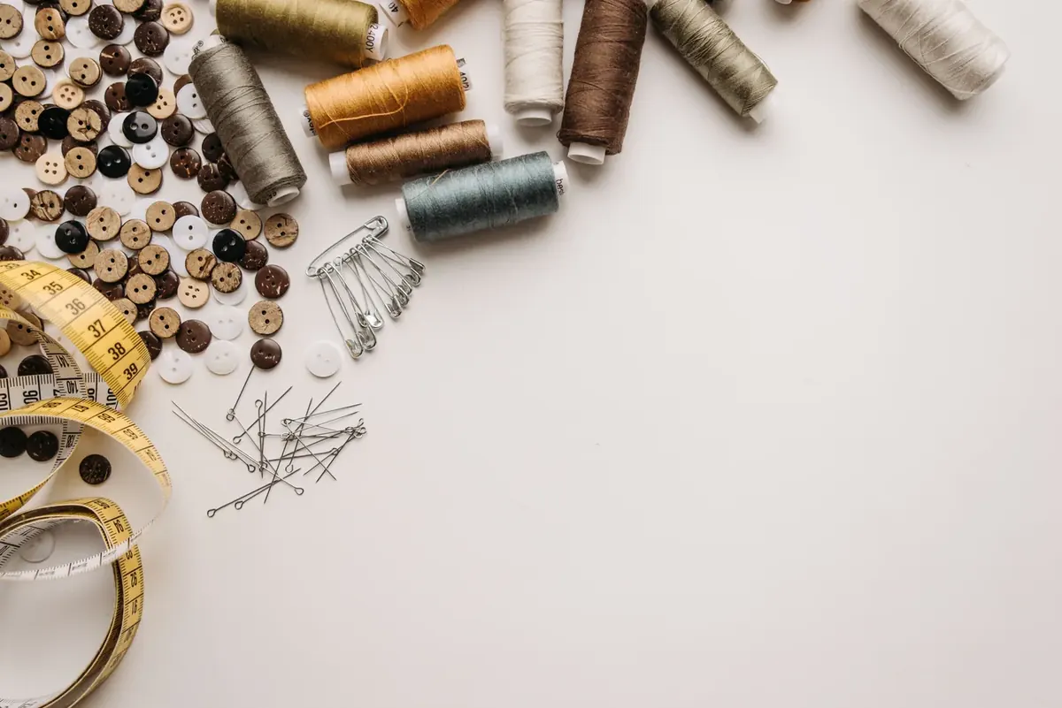 Measuring tape and sewing tools arranged on a neutral surface