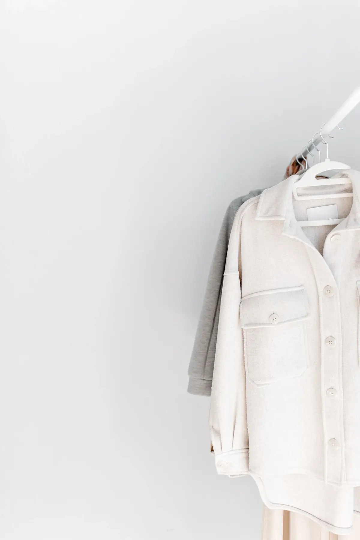 Neutral wardrobe garments arranged on a clothing rack