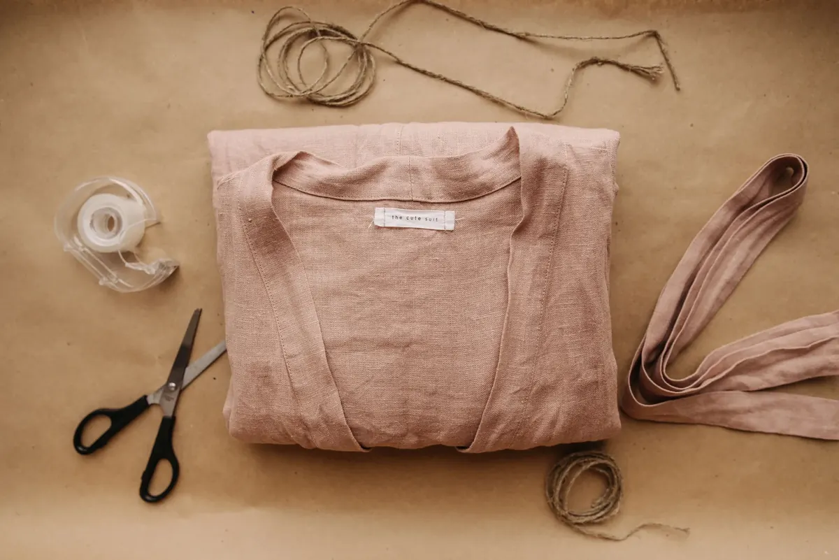 Folded garment and tailoring tools arranged on a warm work table