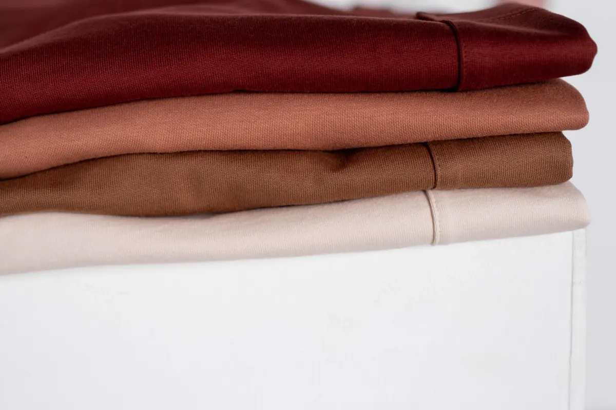 Folded earth-tone garments showing smooth soft textile surfaces