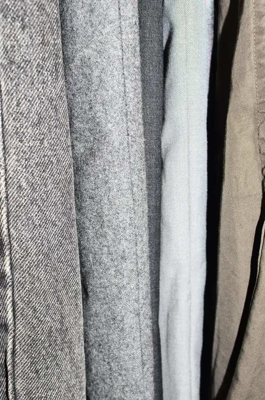 Close-up row of different neutral clothing fabrics hanging together