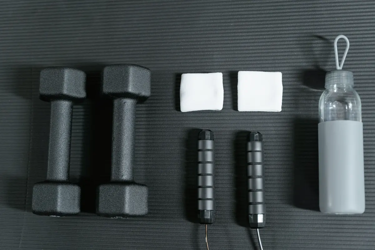 Simple workout essentials arranged on a dark exercise mat